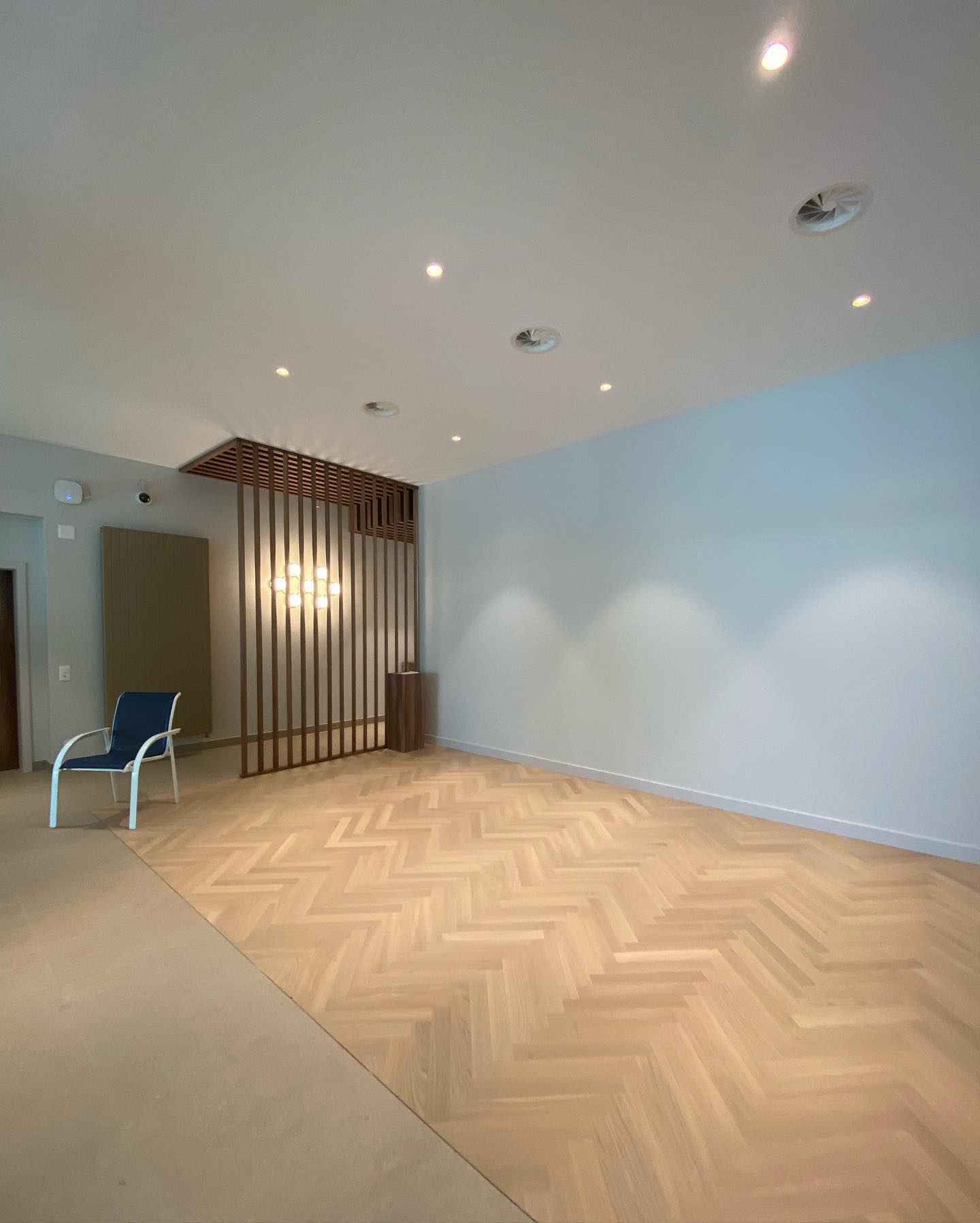 Pièce avec parquet en chevrons et claustra en bois